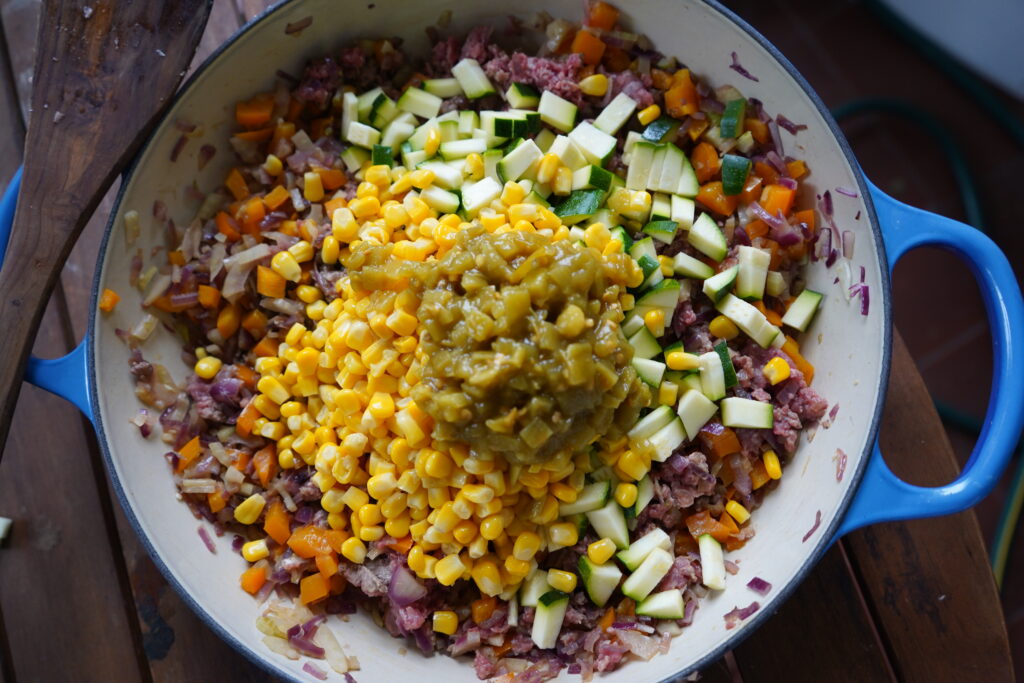 corn and chilis added to a beef skillet