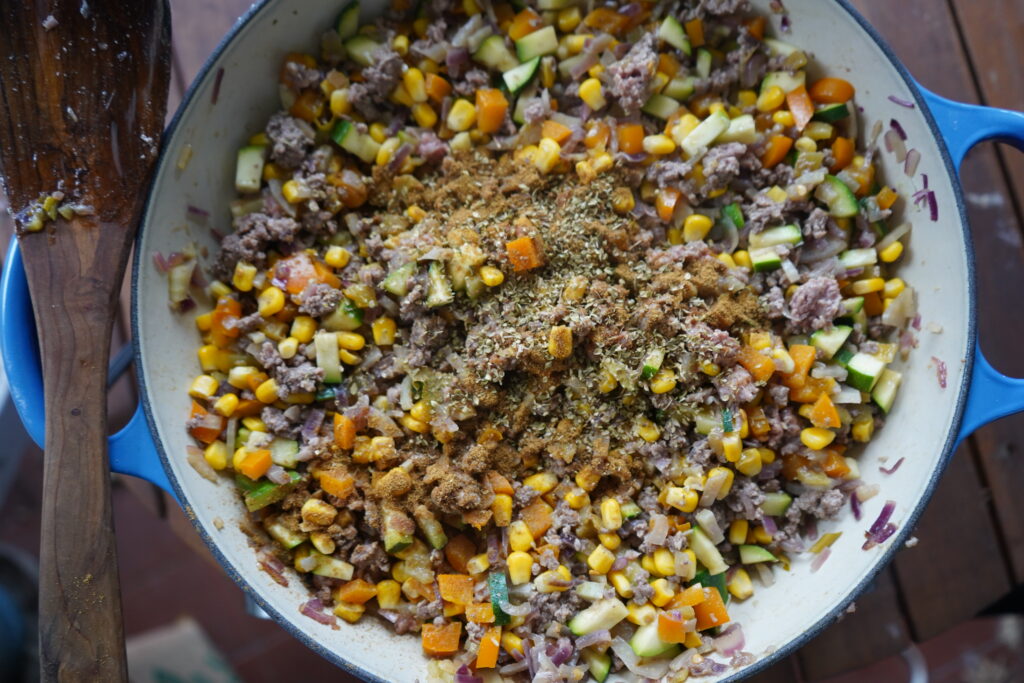 seasonings ontop of a skillet of beef and vegetables