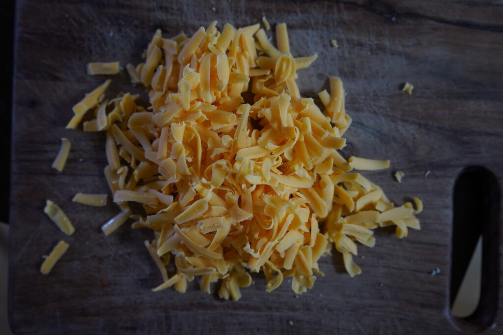 shredded cheese on a cutting board