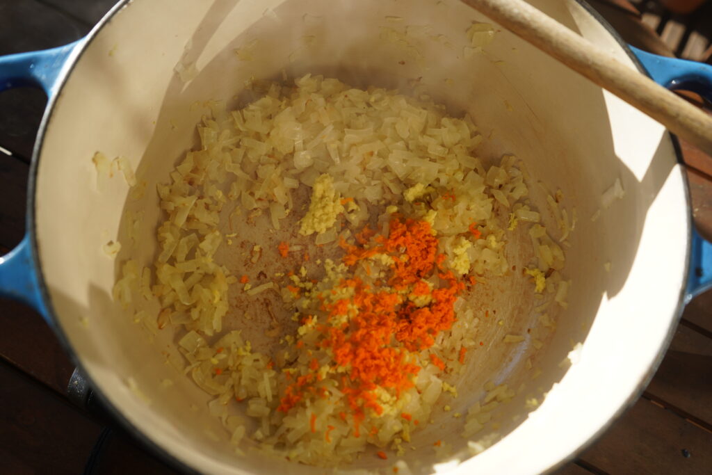 minced giner and garing ona bed of sauteed onion in a dutch oven