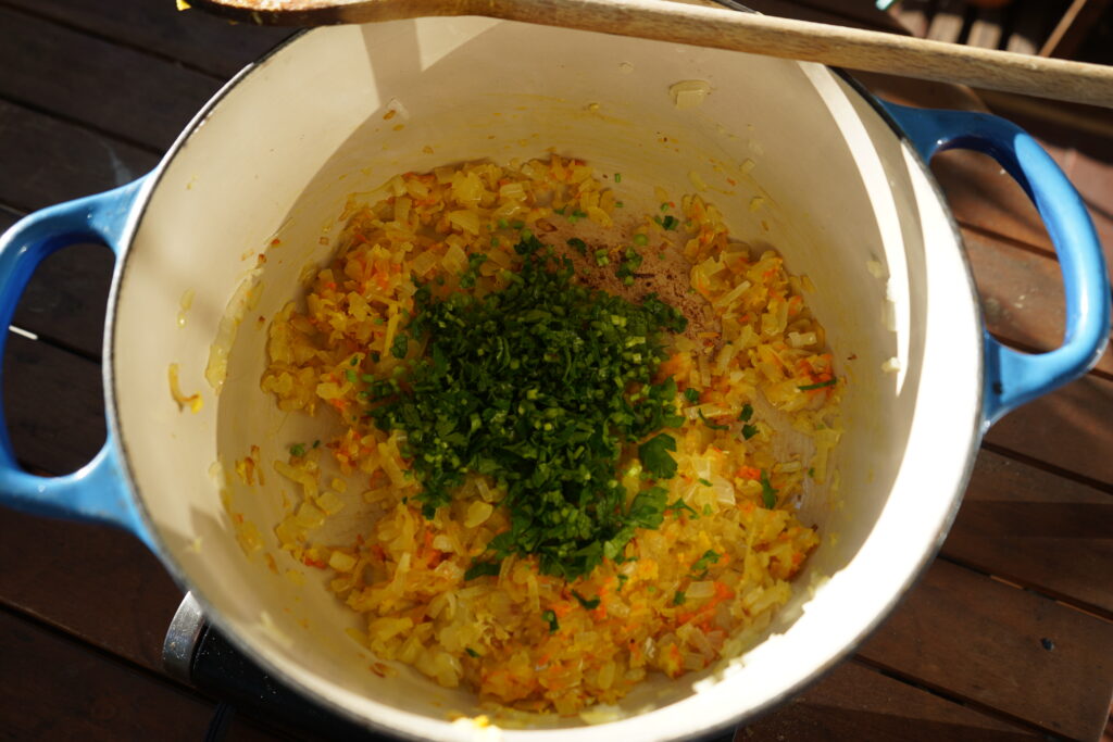 parsley stems added to a pot of sauteed onion